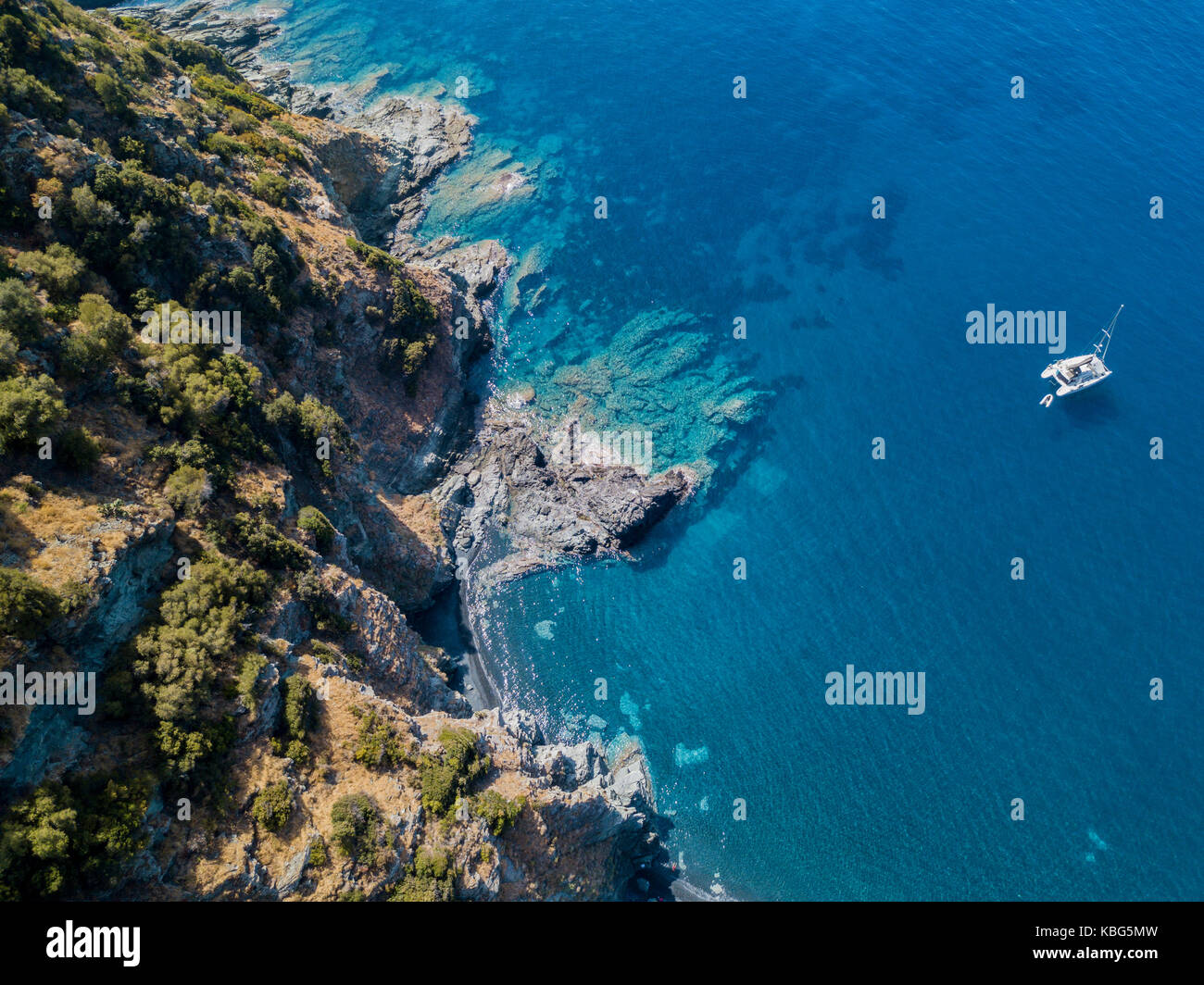 Luftaufnahme von einer Klippe mit Blick auf das Meer und einem Verankerten Katamaran, Boot. Cap Corse Halbinsel, Korsika. Küste. Frankreich Stockfoto