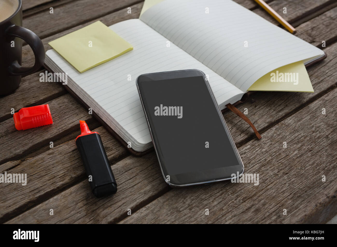 Nahaufnahme der Veranstalter, Kaffee, Mobiltelefon und Schreibwaren auf Holzbrett Stockfoto