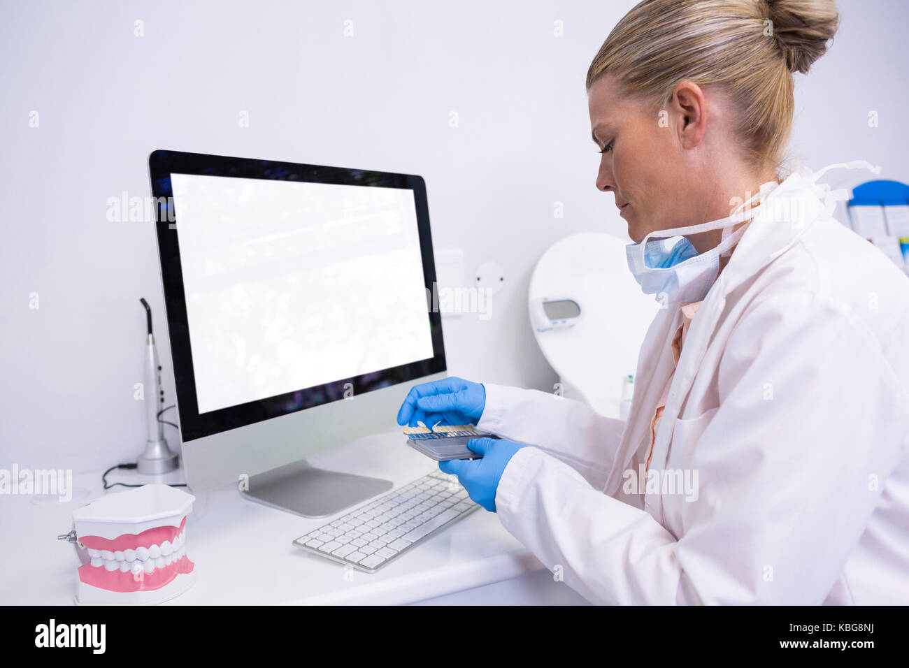 Seitenansicht des Zahnarzt arbeiten, während der Computer an der Klinik sitzen Stockfoto