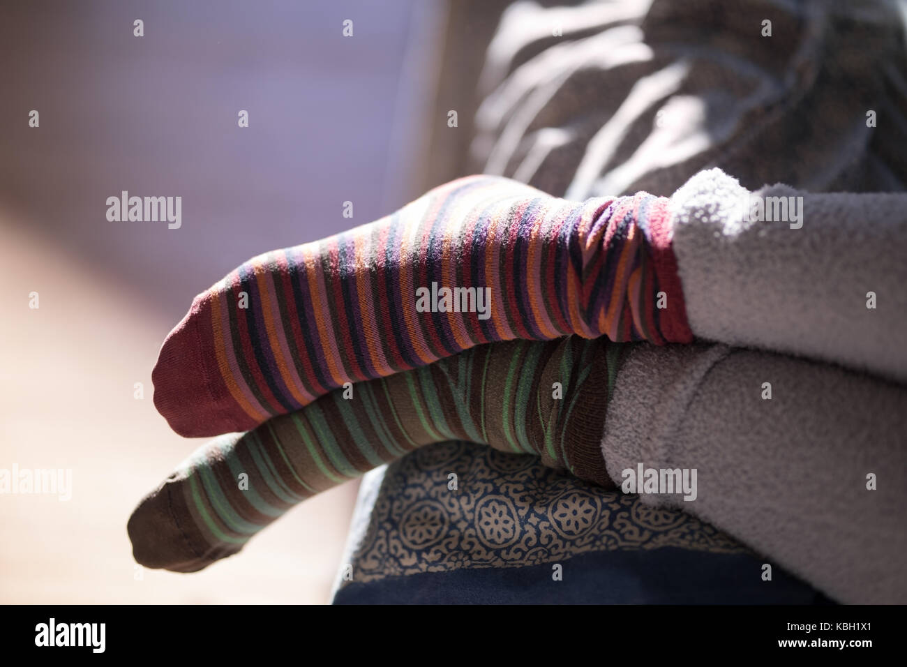 Womans Füße tragen bunte Socken zu Hause Stockfoto