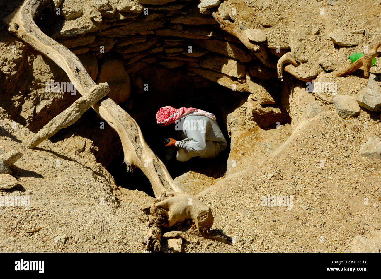 Erkunden dunkle Tiefe des alten Wasserloch im Süden von Ägypten Wüste des Wadi El Gemal Nationalpark Stockfoto