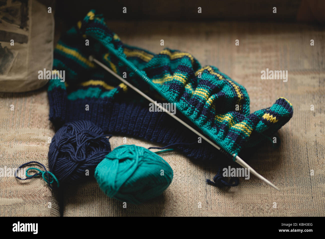 Kugeln von Garn und Stricknadeln auf dem Sofa im Wohnzimmer. Stockfoto