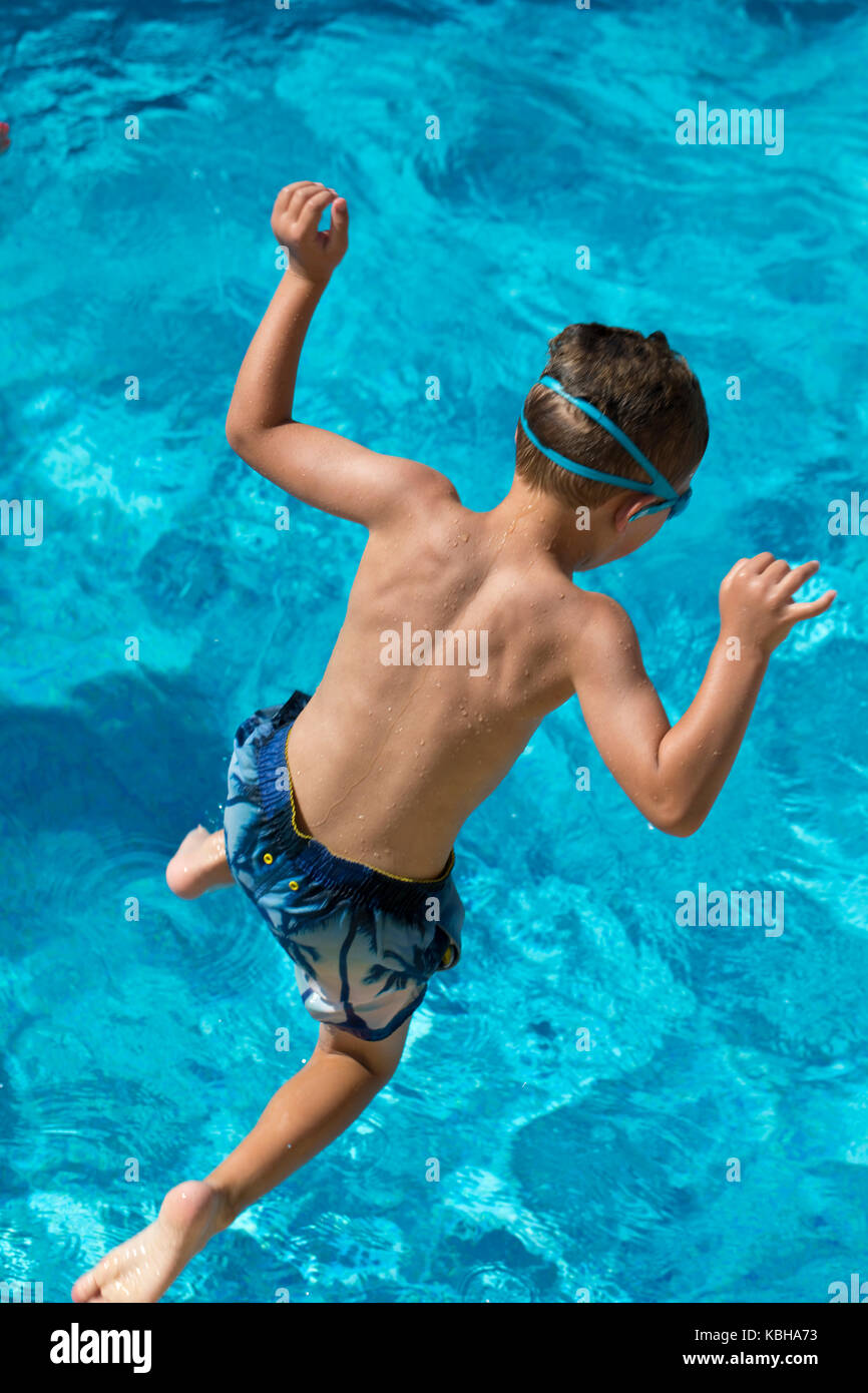 Junge springen in einem Pool Stockfoto