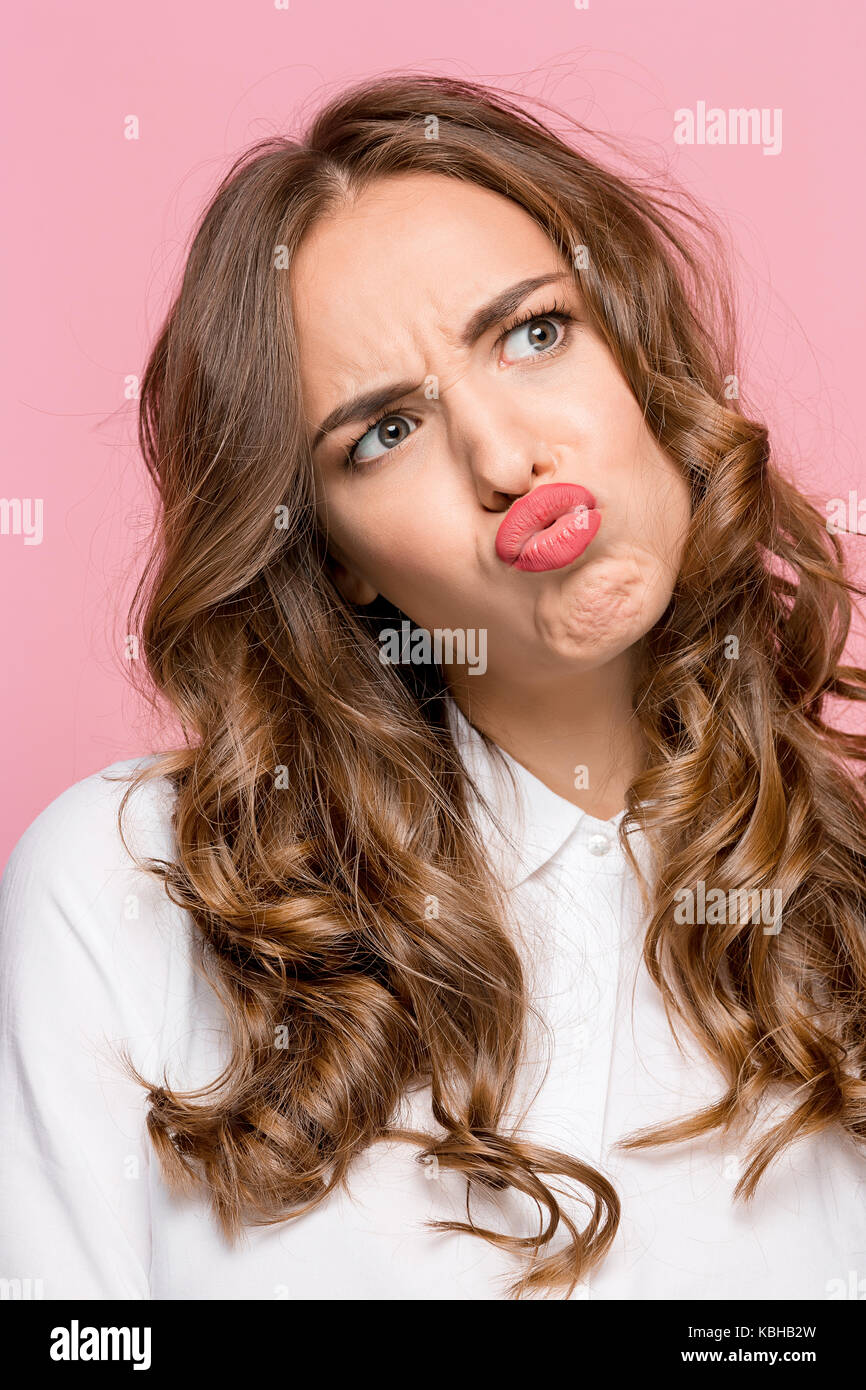 Close-up Porträt einer Frau, ein Fisch Mund Ausdruck, über einen rosa Hintergrund Stockfoto