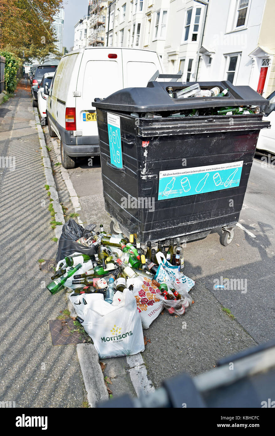 Nicht gesammelte Glasflaschen, die von kommunalen Recyclingbehältern in Brighton, Großbritannien, auf der Straße liegen gelassen wurden Stockfoto