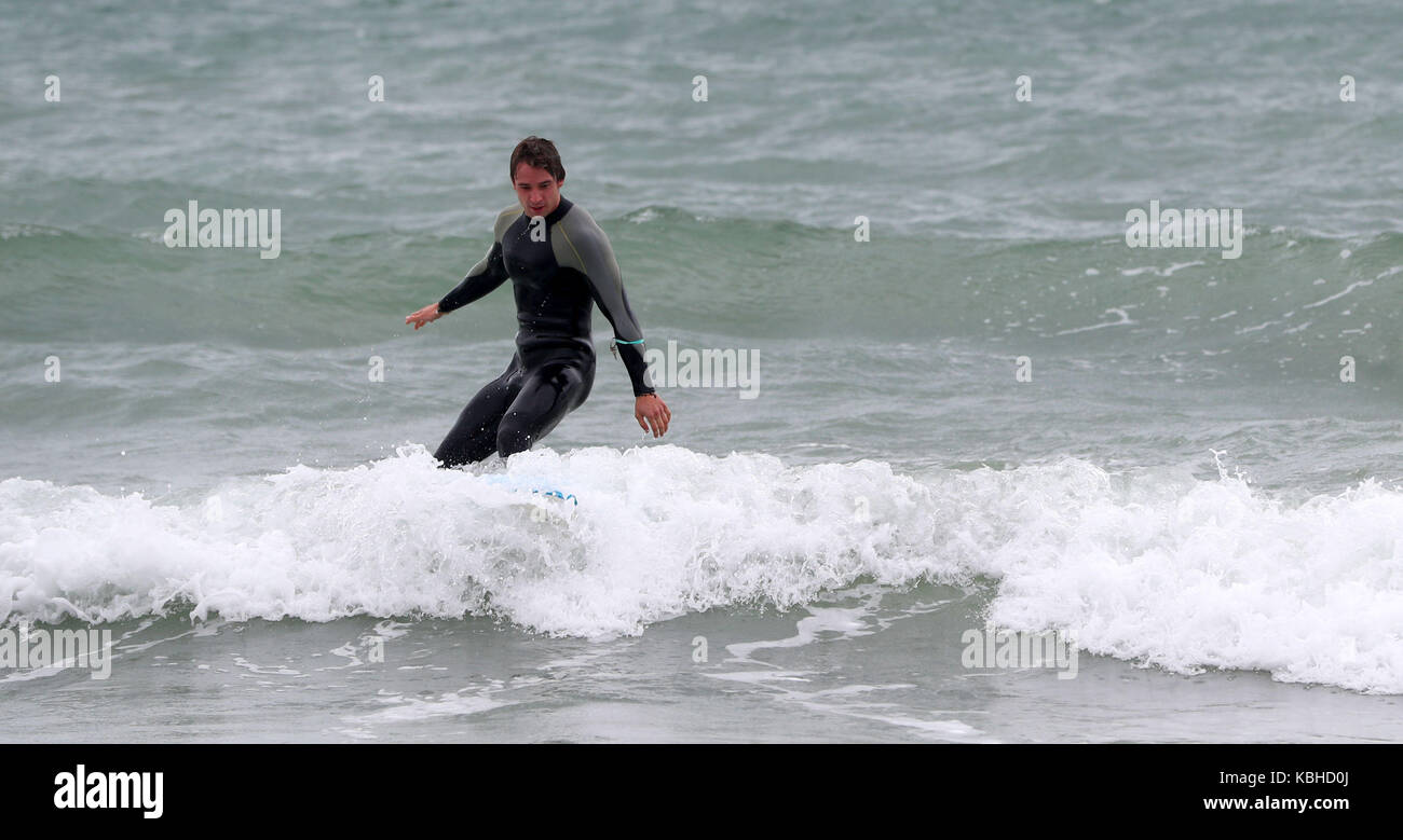 Ein Surfer reitet auf einer Welle am Strand von Boscombe, Bournemouth, da Großbritannien auf Kurs ist für heftige Regenfälle und Stürme, während die Überreste des Windsurfers Lee einem Niederdrucksystem, das sich über den Atlantik bewegt, „zusätzlichen Schwung“ hinzufügen, sagten Prognostiker. Stockfoto