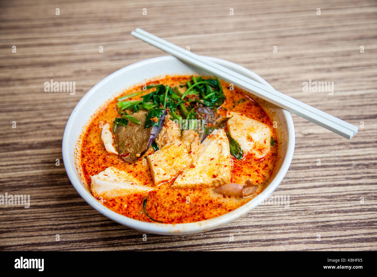 Eine Schüssel von Singapur Laksa Yong Tau Foo, eine populäre lokale Gericht in pikanter Soße serviert curry Garnelenpaste Suppe mit Kokosmilch; Tofu und Aubergine f Stockfoto