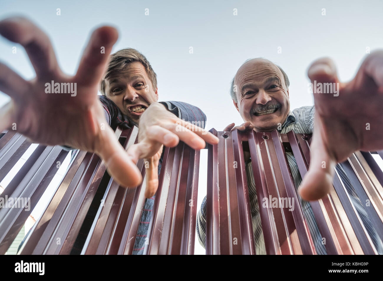Zornigen Mann wütend klettert über den Zaun und brechen die Grenzen des privaten Eigentums und seine Hand nach unten ziehen. Stockfoto
