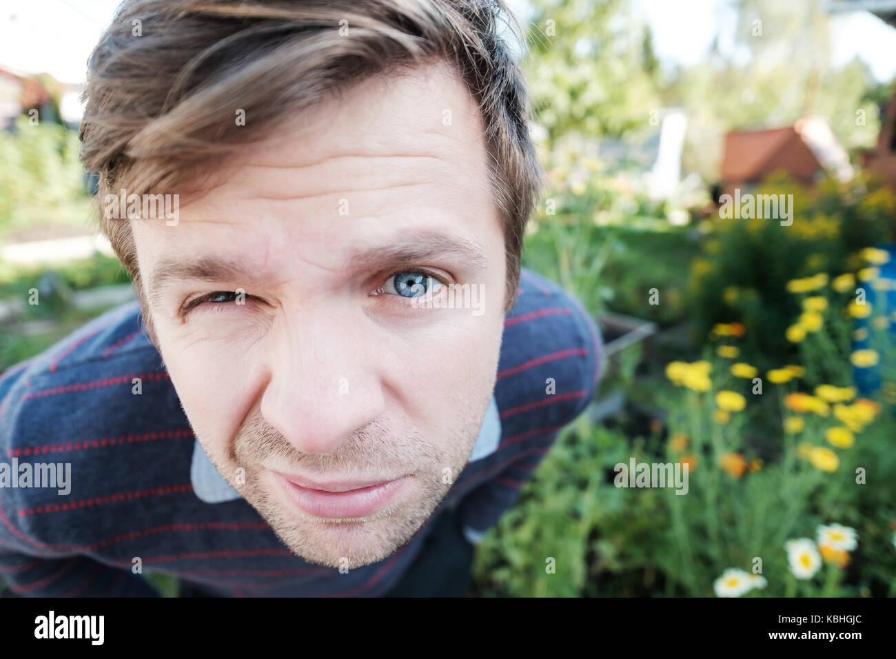 Porträt eines Mannes mit blauen Augen in die Kamera schaut mit fragenden und verdächtige Gesichtsausdruck Stockfoto