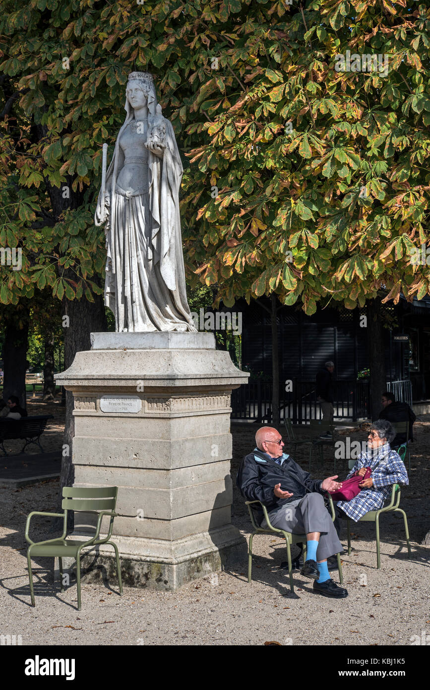 Ein paar nehmen im Herbst Sonnenschein unter der Statue von Bertha Broadfoot von Eugène Oudiné in Luxembourg, Paris, Frankreich. Stockfoto