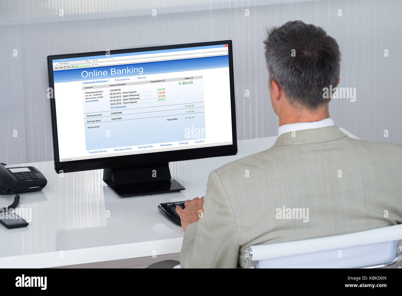 Ansicht der Rückseite des Geschäftsmann tun Online Transaktion am Schreibtisch im Büro Stockfoto