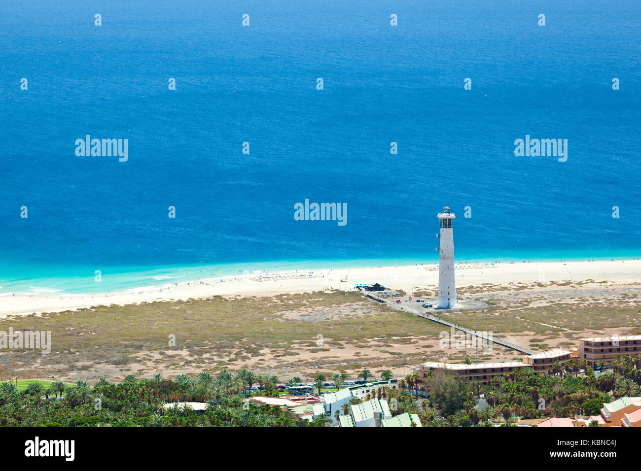 Blick von einem Hügel in den wunderschönen, endlosen Strand von Jandia in der Nähe von Morro Jable mit dem Leuchtturm von Jandia, Fuerteventura. Stockfoto