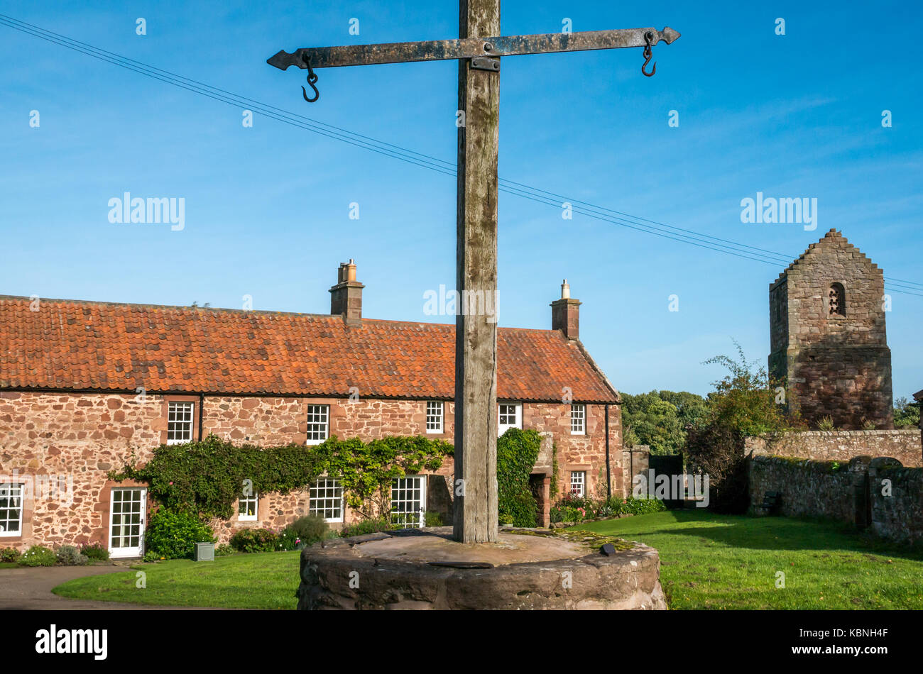 Sonnigen Tag in Stenton Village Green, East Lothian, Schottland, Großbritannien mit roten Schutt Steinhütten, dovecot und den alten Markt Waage Stockfoto