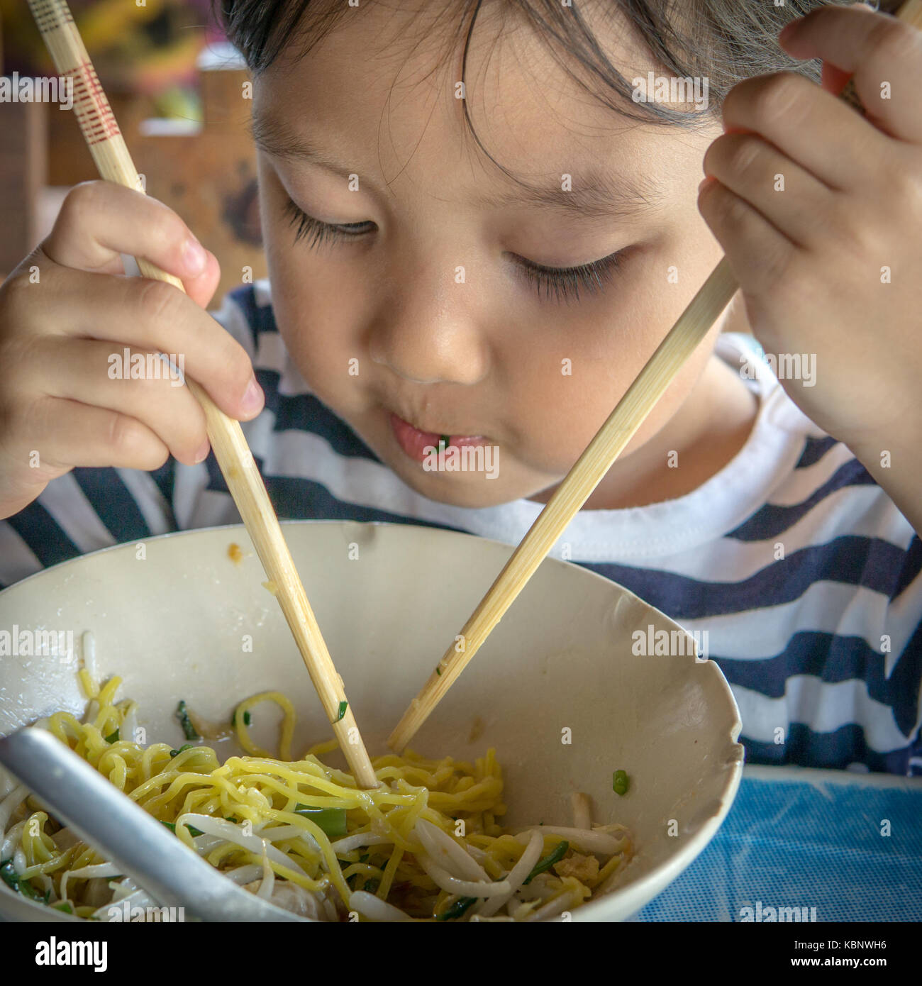 Kind mit Stäbchen Essen Nudel Stockfotografie - Alamy