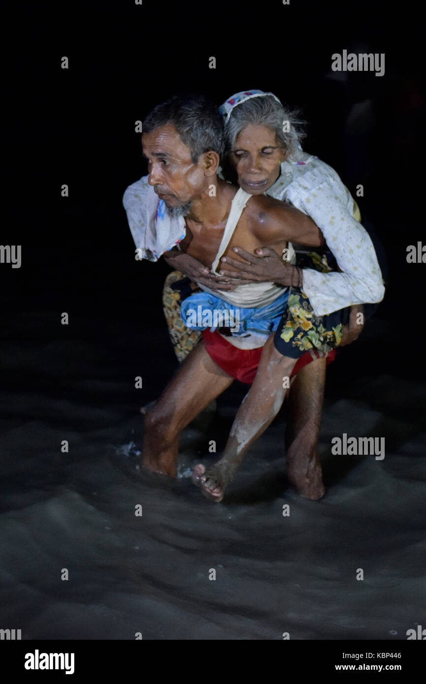 COX'S BAZAR, BANGLADESCH - 30. SEPTEMBER 2017: Auf einer dunklen Nacht Myanmars Minderheit Rohingya muslimische Flüchtlinge aus ein Boot am Ufer des Naf Riv aussteigen Stockfoto