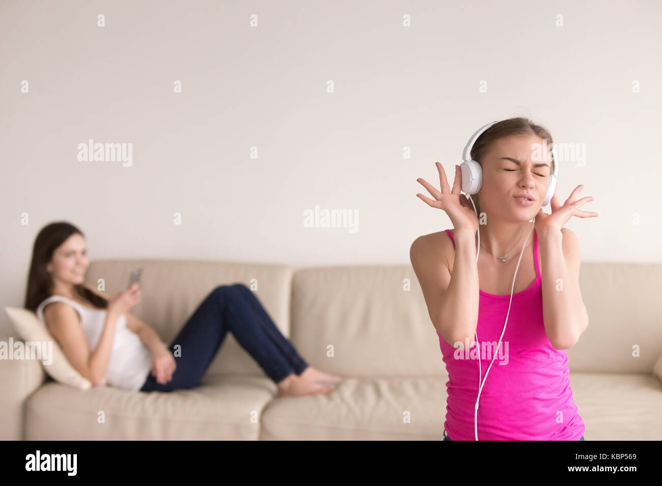 Junge Mädchen Musik hören und ihre Freundin Entspannen auf dem Sofa. Stockfoto
