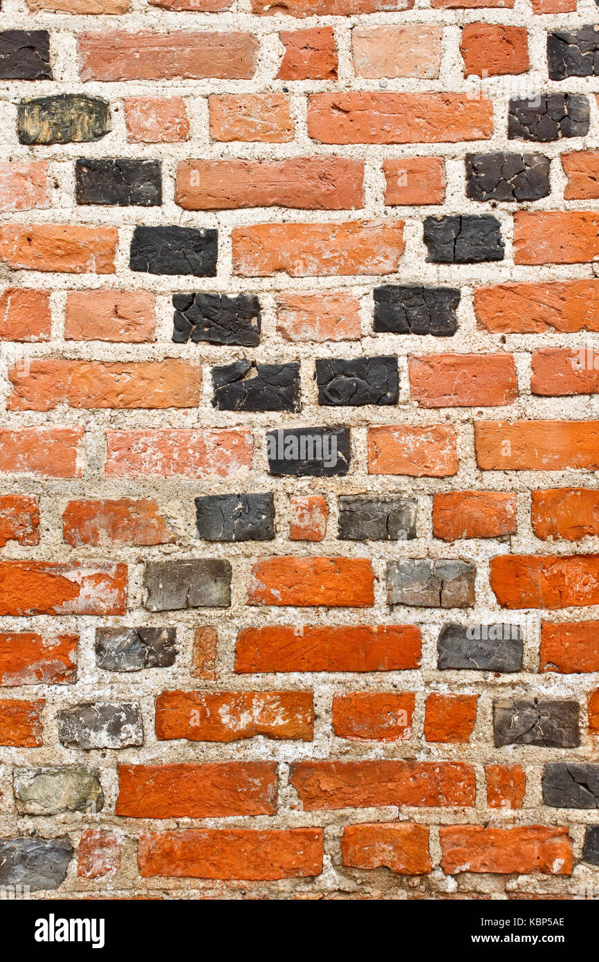 Alten grunge Red brick wall mit schwarzen Kreuzung diagonale Linien Stockfoto