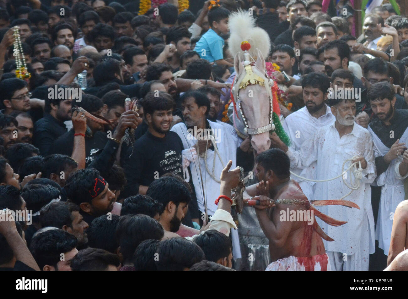 Pakistanische schiitische Muslime selbst erstechen während einer religiösen Prozession vor ashura am neunten Tag des heiligen Monats Muharram in Lahore am 30. September 2017 abgehalten. schiitischen muslimischen Anhänger Ketten verwendet, sich selbst zu motivieren bei einem ashura Prozession das Martyrium des Imam Hussain, der Enkel des Propheten Mohammed zu gedenken. des islamischen Monats Muharram kennzeichnet die sieben - Jahrhundert des Martyriums der Enkel des Propheten Mohammed Imam Hussein, der in der Schlacht von Kerbala im Irak 680 getötet wurde. Ashura ist eines der wichtigsten Festivals für die schiitischen Muslime, und fällt auf den 10. Tag des Muharram, Stockfoto