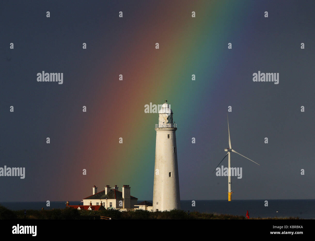 Ein Regenbogen über der St Mary's Leuchtturm in der Nähe von Whitley Bay in Tyne und Wear, da mehr ungeklärten Bedingungen für dieses Wochenende wahrscheinlich Aussehen und dem Beginn der nächsten Woche. Stockfoto