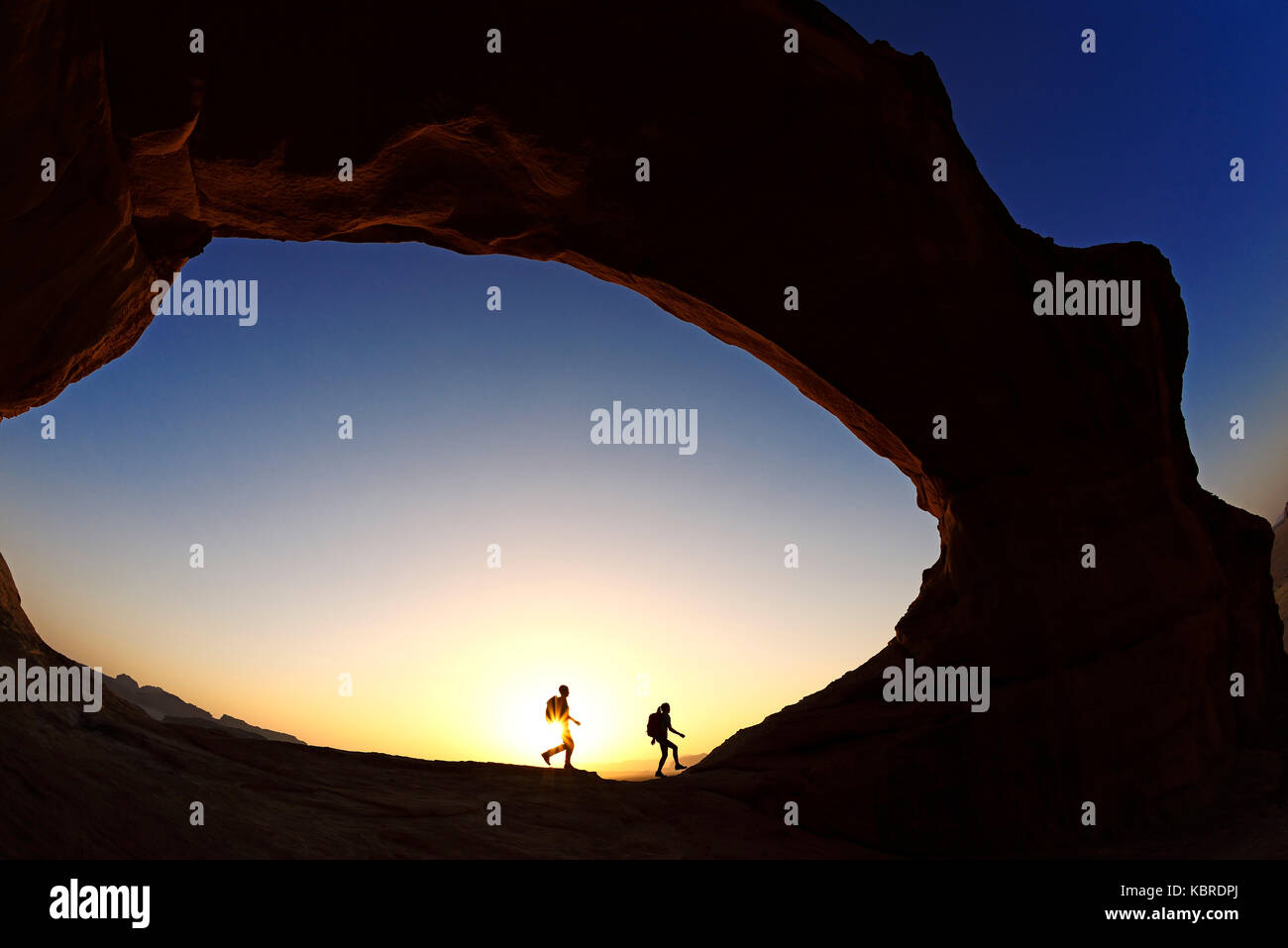 Paar Wandern am Rock-arch Al kharza, Wadi Rum, Jordanien Stockfoto