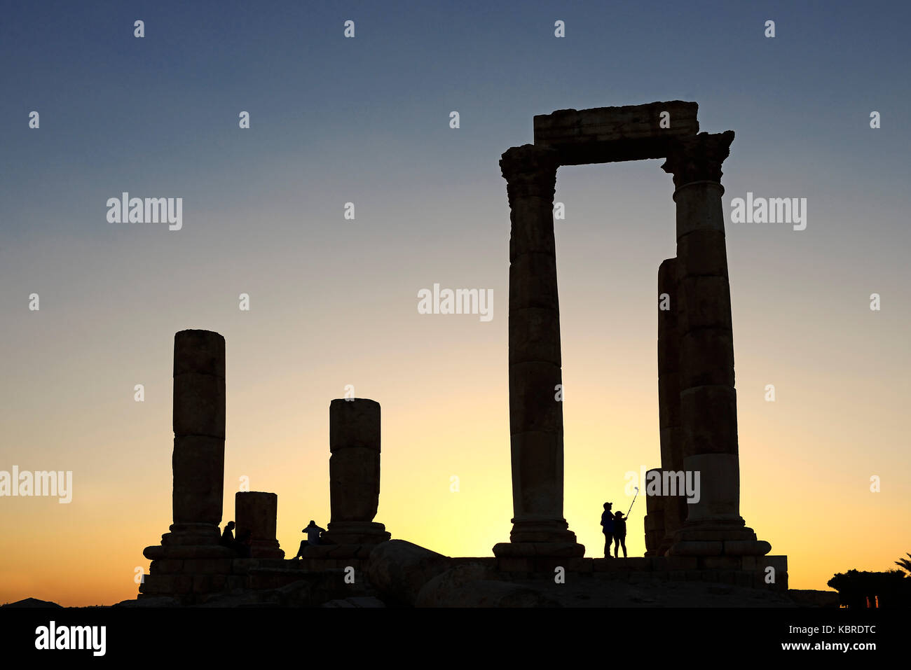Paar nimmt Bilder mit einer selfie-Stick im Sonnenuntergang beim Tempel des Herkules in der Zitadelle, Amman, Jordanien Stockfoto