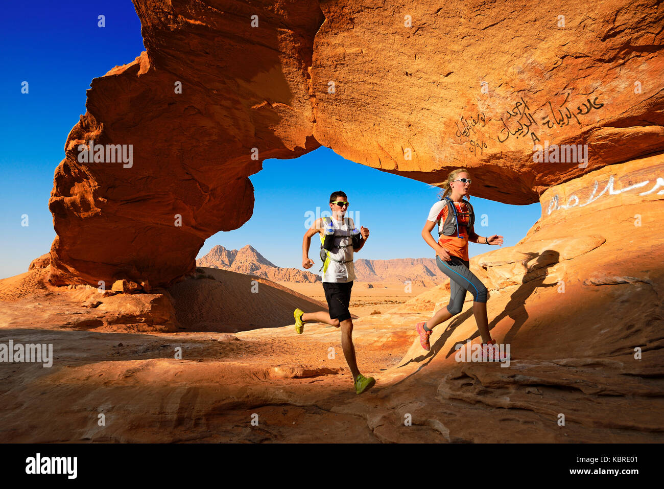 Paar Trail in Rock running-arch namens Al kharza, Wadi Rum, Jordanien Stockfoto