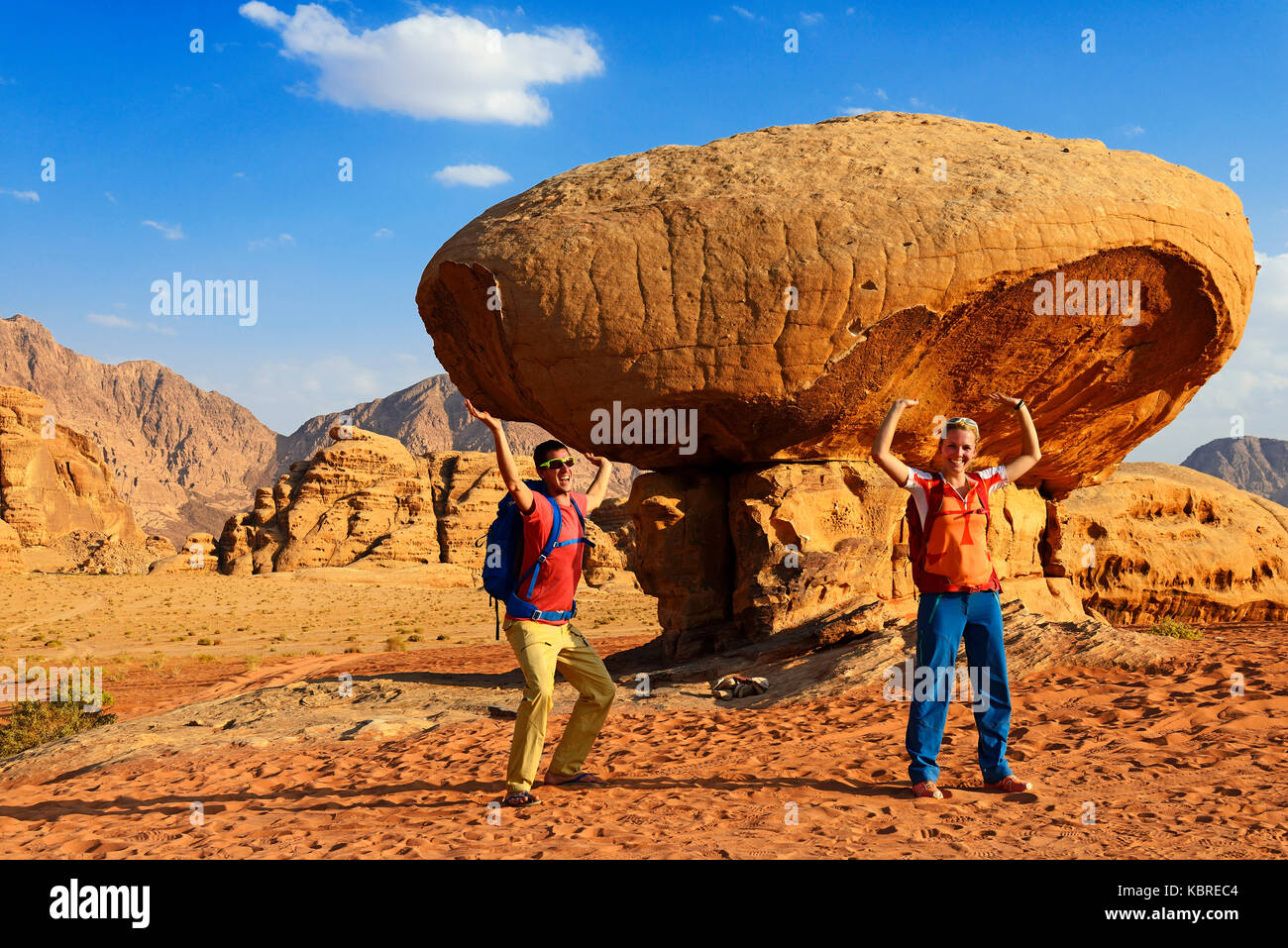 Touristen posieren bei Mushroom-Rock, Al Fetra, Wadi Rum, Jordanien Stockfoto
