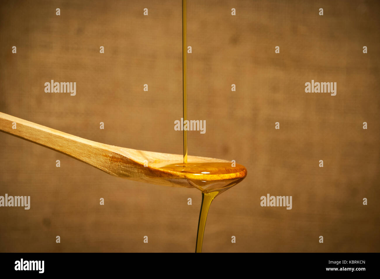 Olivenöl über die hölzerne Löffel läuft, auf retro Hintergrund Stockfoto