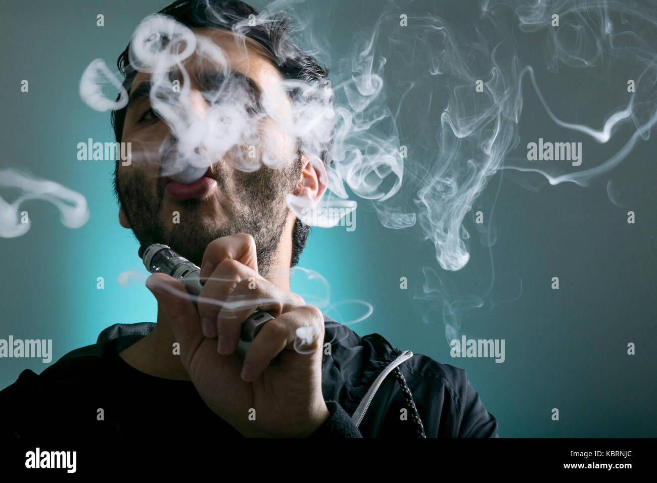 Junger Mann vape Elektronische Zigarette Cloud mit einem Mod, Rauch Tricks  der vaping Gerät Hintergrund Stockfotografie - Alamy