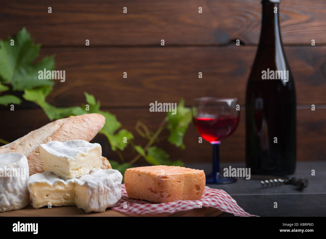 Variation von Käse, Wein und Brot auf einem Tisch aus Stein Stockfoto