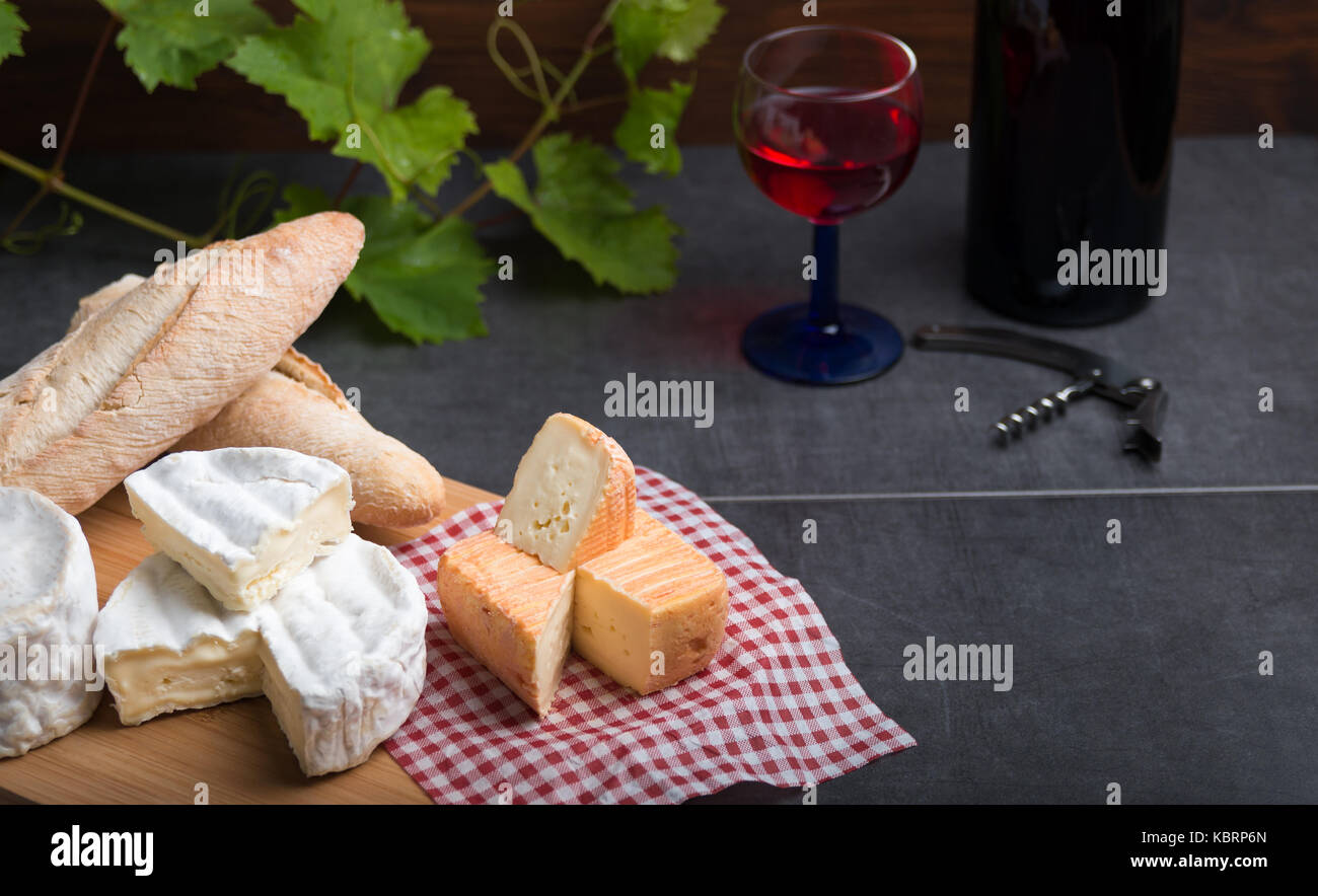 Variation von Käse, Wein und Brot auf einem Tisch aus Stein Stockfoto