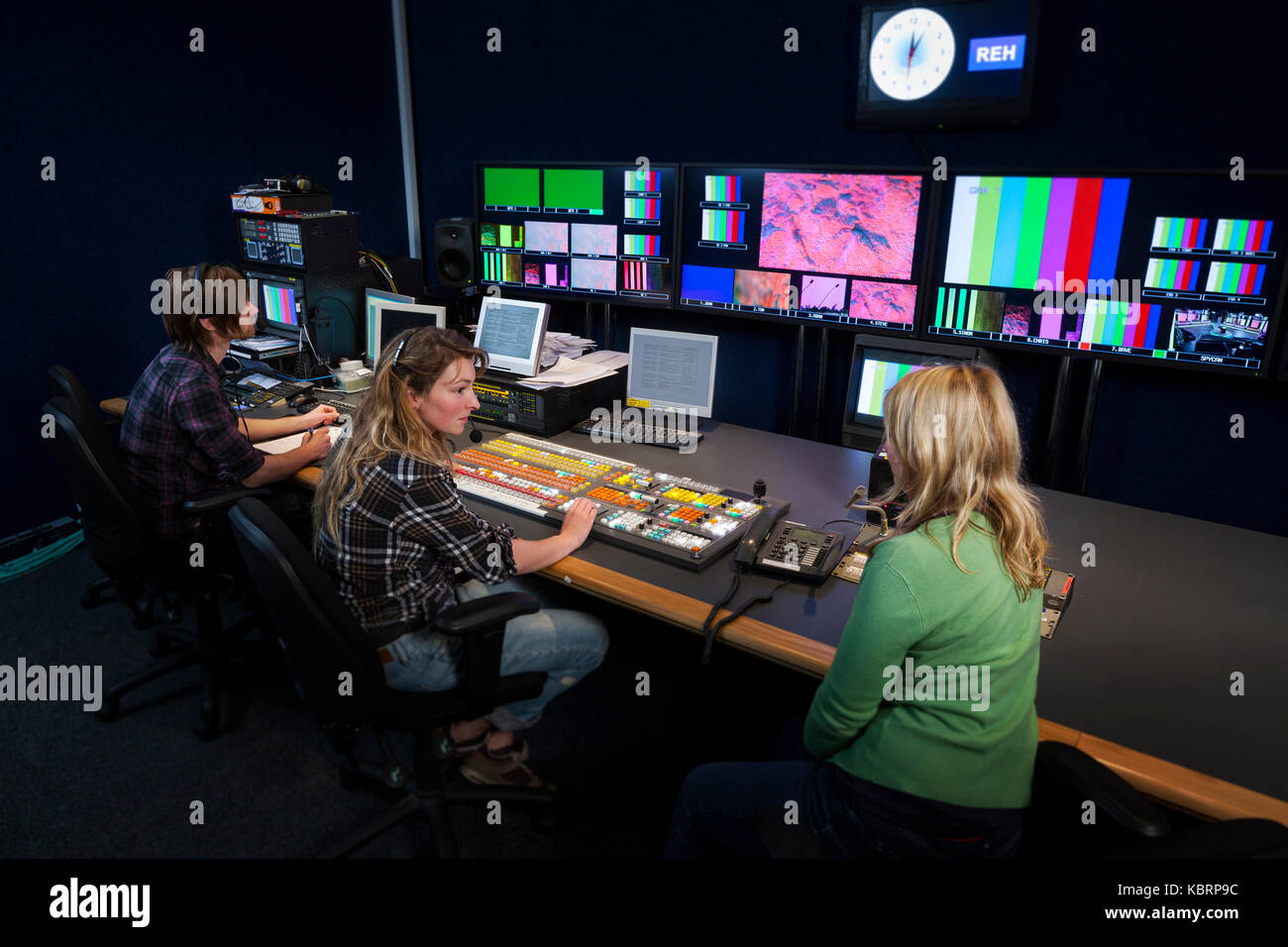 TV-Regisseur im Gespräch mit ihrer Vision Mixer in einem TV-Galerie. Stockfoto