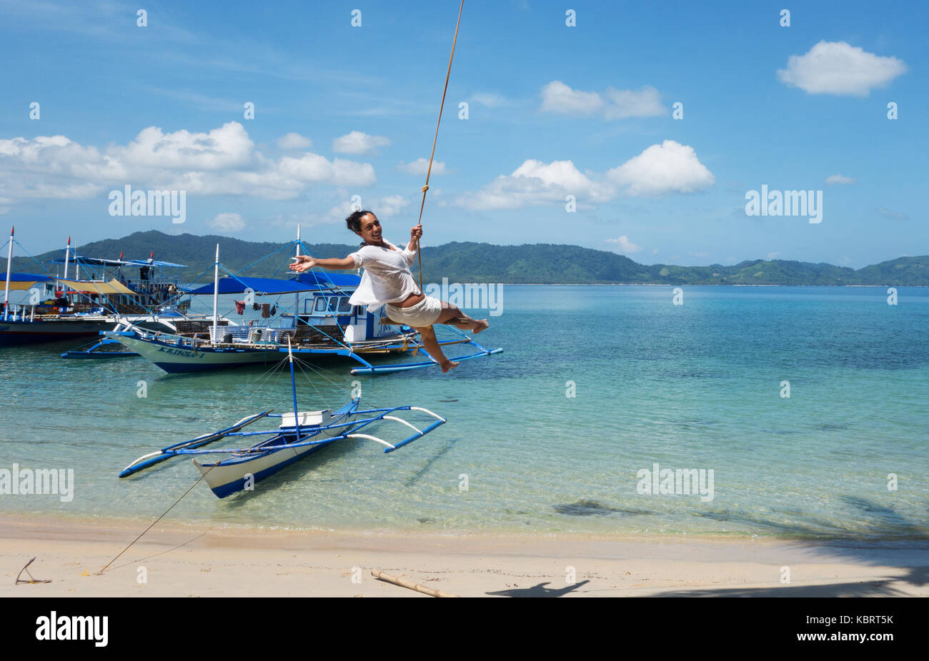 Philippinen - Eine touristische Spaß auf einem Seil schwingen, El Nido Strand, El Nido, Palawan, Philippinen Asien Stockfoto
