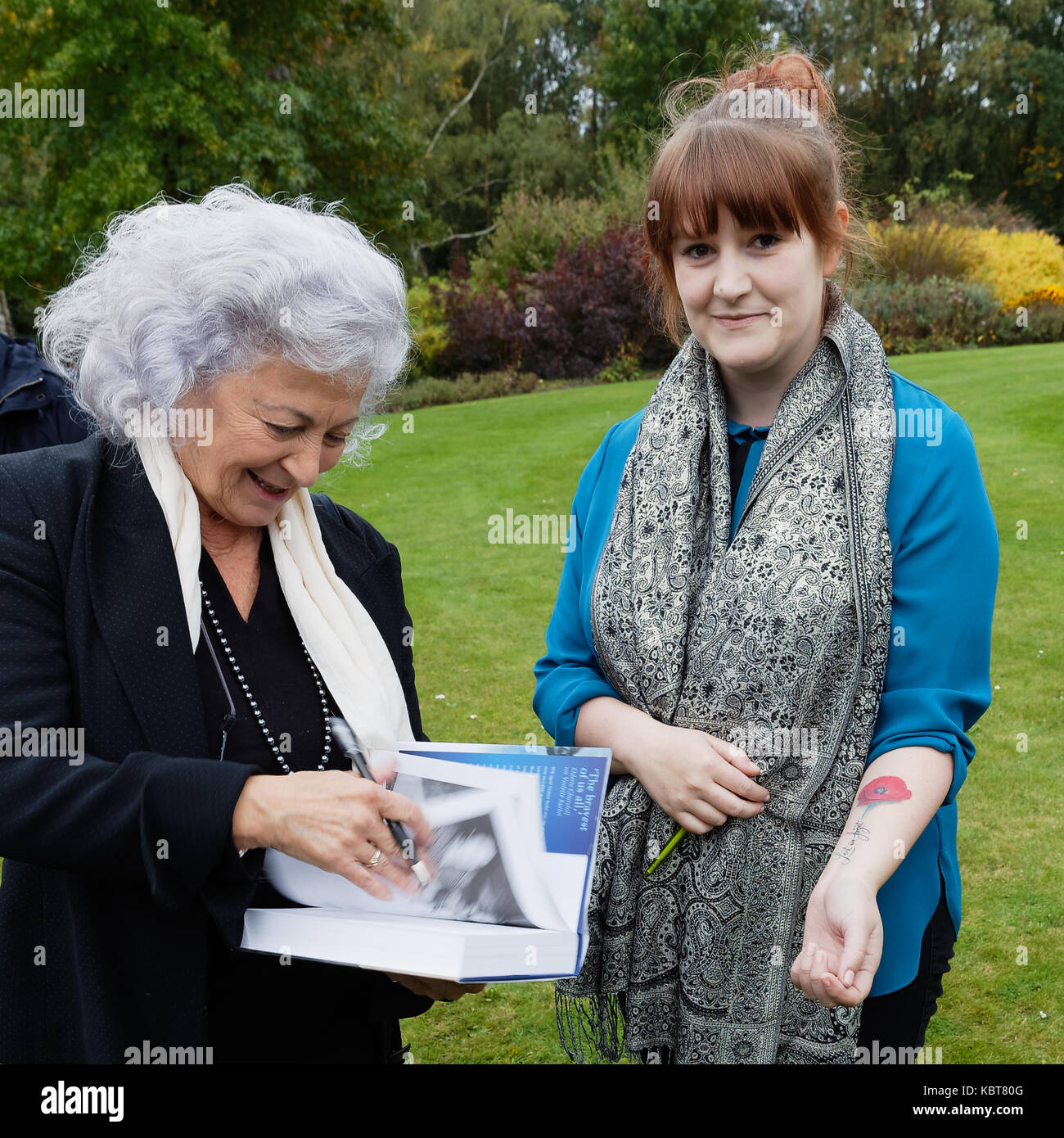 Commonwealth Kriegsgräber Friedhof Brookwood UK Tania Szabo, Thema Zeichen ihr Buch über ihre Mutter für ein 'Fan' mit einer 'Gegen das Vergessen' poppy Tattoo. Stockfoto