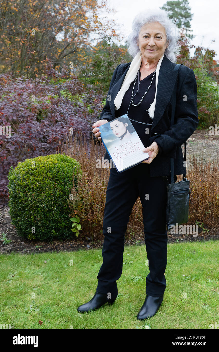 Commonwealth Kriegsgräber Friedhof Brookwood Surrey, England. Tania Szabo mit dem Buch, das sie über ihre Mutter verfasst - "Junge Mutig und schön. Die Missionen der Special Operations Executive Agent Lieutenant Violette Szabo.' Stockfoto