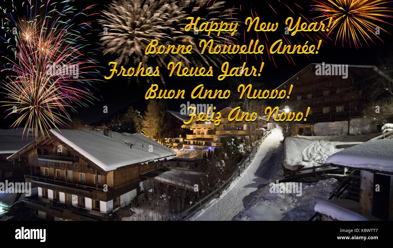 Vorabend des neuen Jahres mit alpinen Dorf im Schnee, Feuerwerk, mulitlingual Begrüßungstext Stockfoto