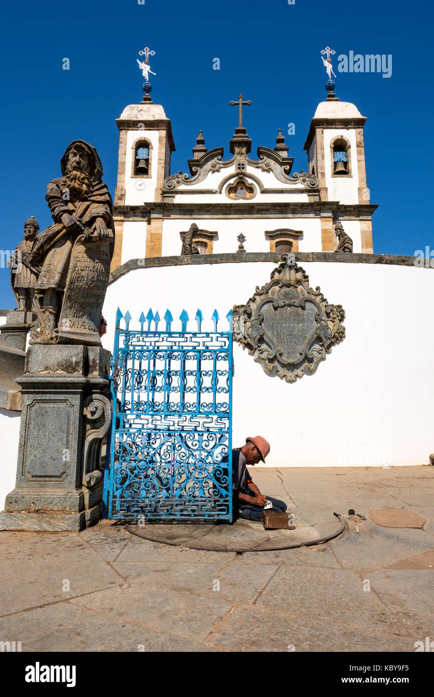 Obdachlosen vor den Toren von Wallfahrtskirche Bom Jesus tun, Matosinhos, Speckstein Statue des Propheten Jesaja, die von Aleijadinho, Congonhas, Minas Gerais, Brasilien. Stockfoto