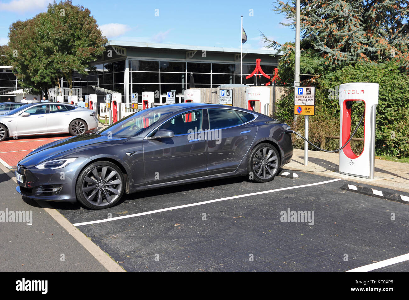 Tesla Elektroautos aufladen an speziellen Ladestationen, Hopwood Autobahn Dienstleistungen, Alvechurch, Birmingham Stockfoto