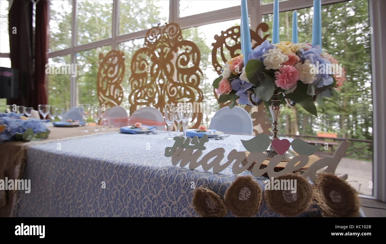 Hochzeit Tabelle an einer Hochzeit mit brautstrauß eingerichtet. Bankettsaal. festliche Tafel für die Braut und den Bräutigam mit einem Tuch und Blumen geschmückt. Tabelle für Braut und Bräutigam. Hochzeit Stockfoto