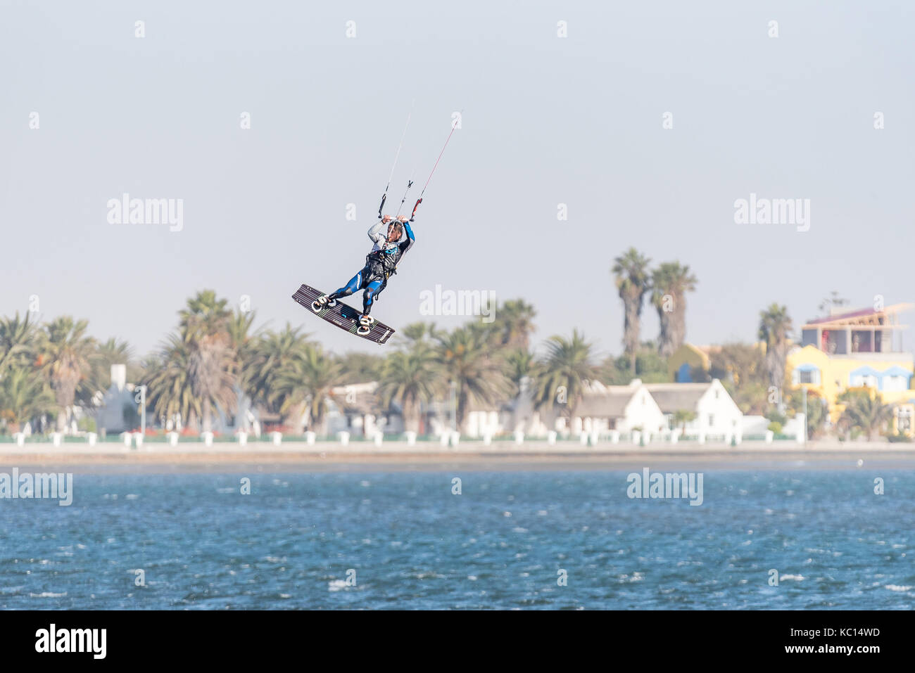 WALVIS BAY, NAMIBIA - Juli 2, 2017: Ein nicht identifizierter Kite Surfer in der Luft an der Lagune von Walvis Bay in der Namib Wüste auf der atlantischen Küste von Nami Stockfoto