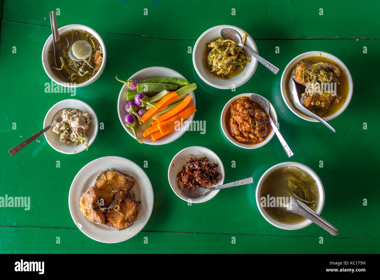 Draufsicht am Tisch mit verschiedenen birmanischen Speisen im lokalen Restaurant in Myanmar. Stockfoto