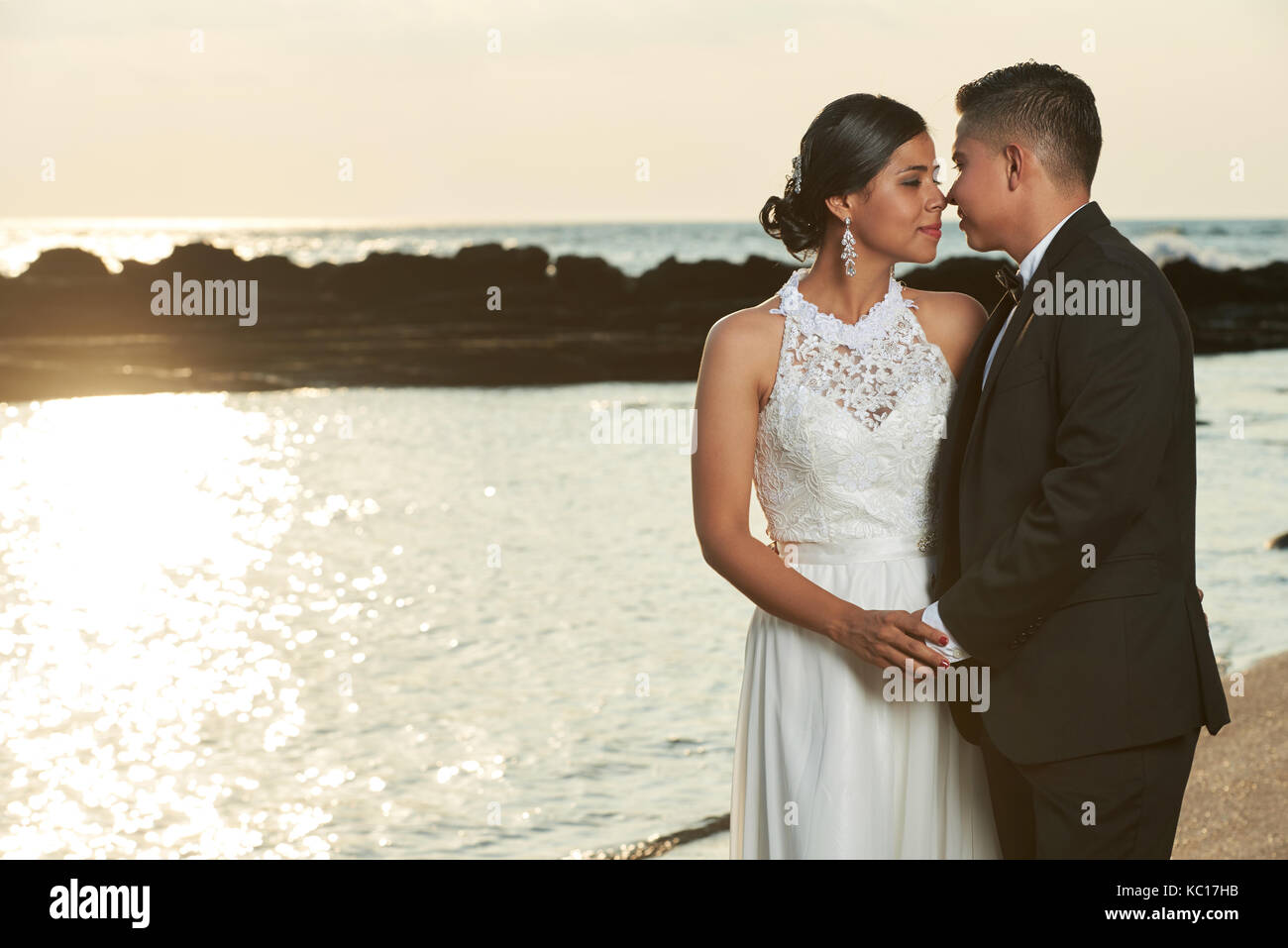 Bräutigam, Braut am Ocean sunset beach Hintergrund zu küssen. Romantische Hochzeit in tropischen Strand Stockfoto