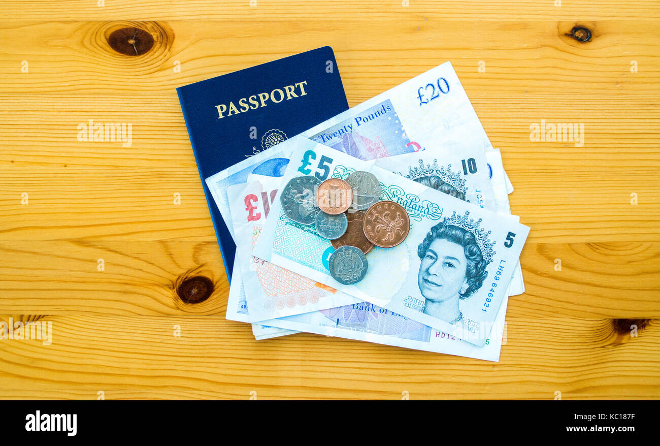 Britisches Geld und einen amerikanischen Pass auf einen hölzernen Tisch Stockfoto