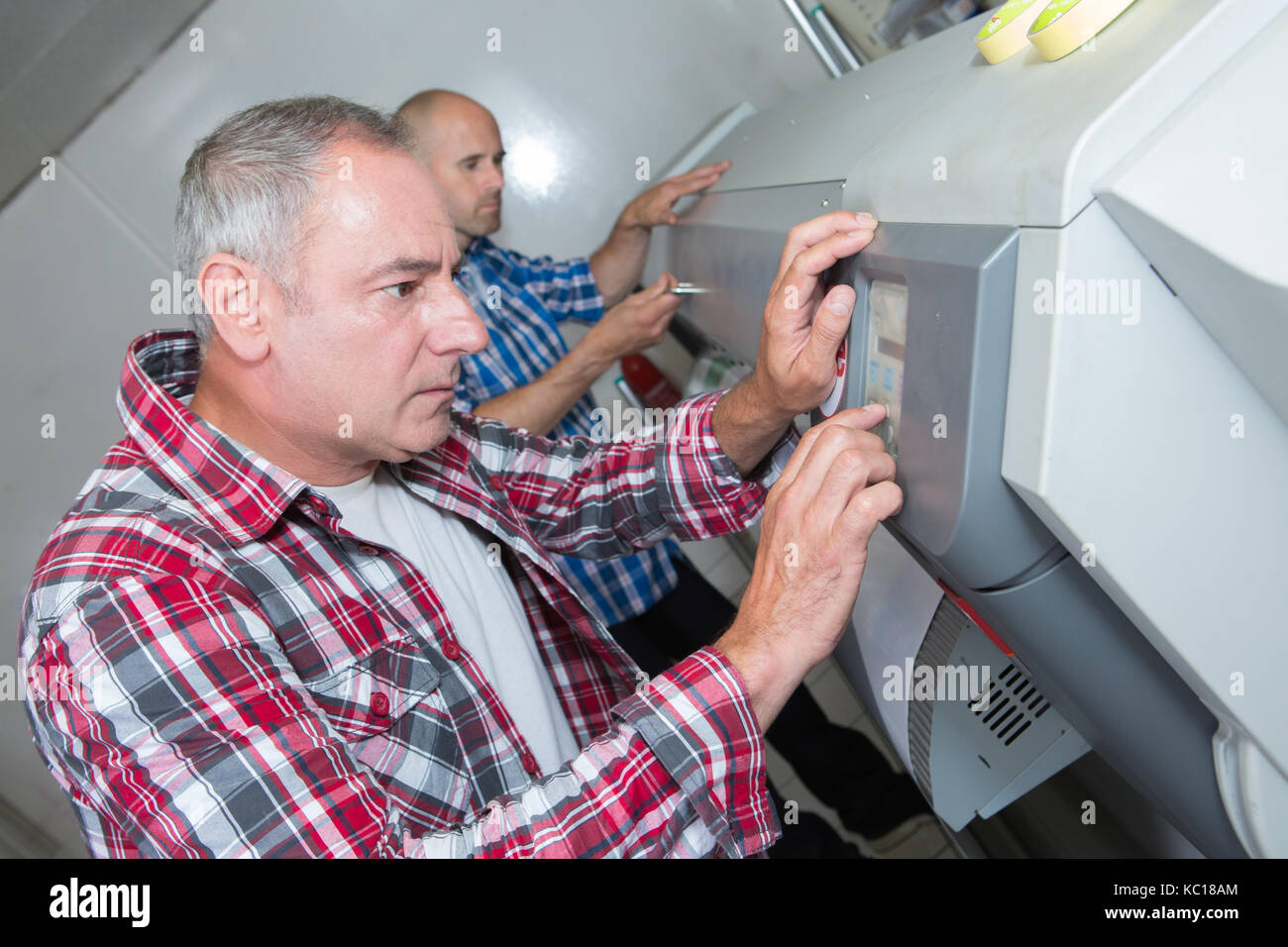 Techniker die Kontrolle einer großen Tintenstrahldrucker Stockfoto