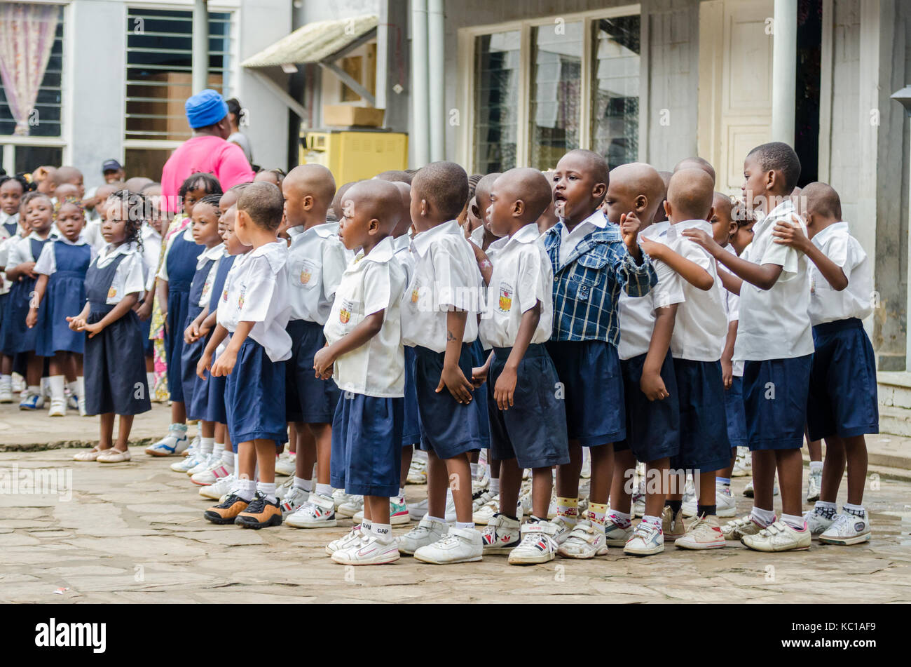 Gruppe junger afrikanischer Vorschulkinder, die in Schulhof, Matadi, Kongo, Zentralafrika tanzen und singen Stockfoto