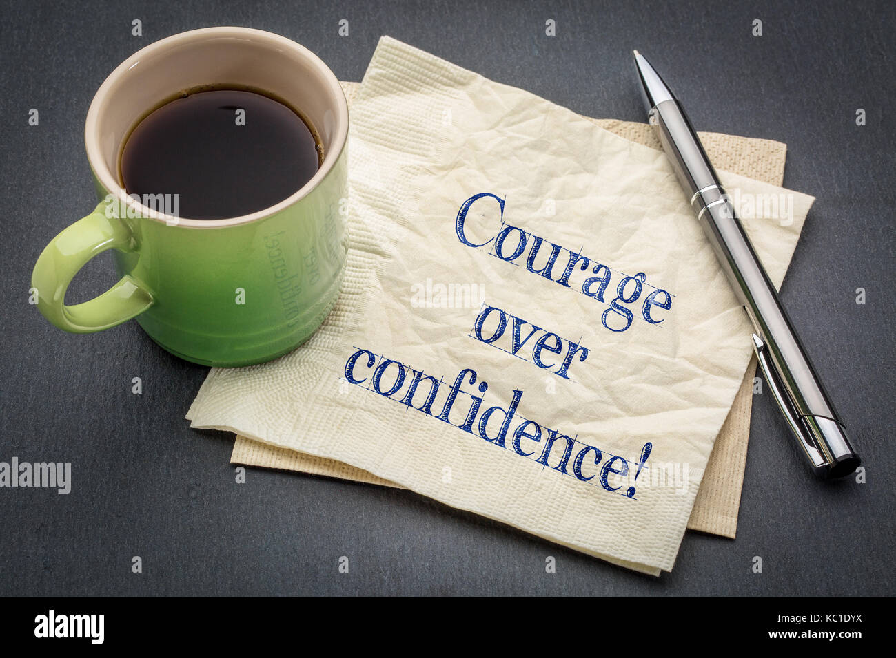 Über vertrauen Mut! Handschrift auf eine Serviette mit Tasse Kaffee gegen grauen Schiefer Hintergrund Stockfoto