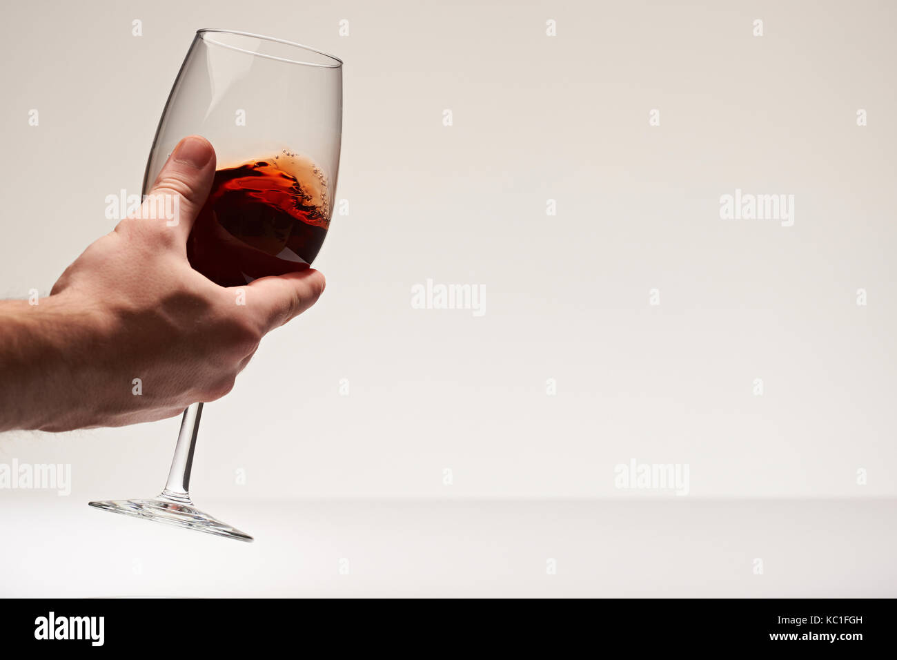 Die Hand schütteln elagant Rotwein Glas isoalted auf weißem Hintergrund Stockfoto
