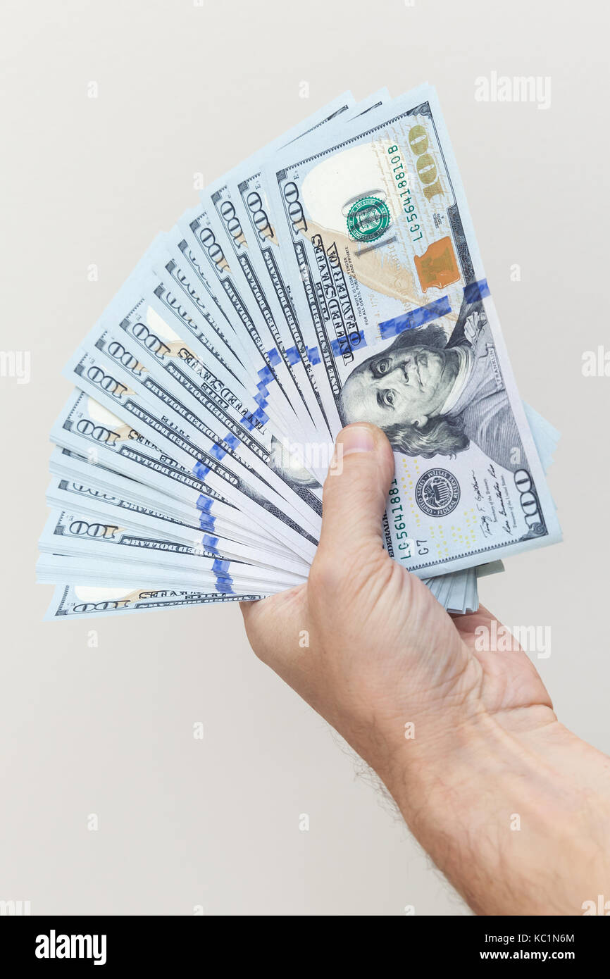 Vertikale Foto. Fan von einhundert Dollar Noten in männlicher Hand über weiße Wand im Hintergrund Stockfoto