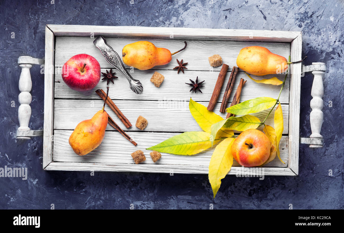 Äpfel, Birnen, Gewürze und im Herbst Laub in einem hölzernen Kasten Stockfoto