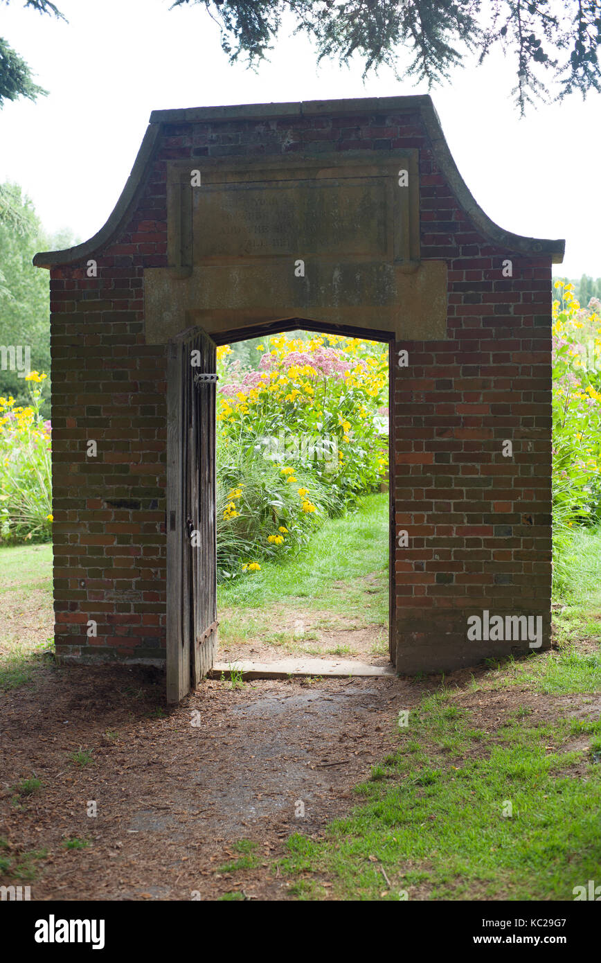 Brick Tür führt in eine Wiese Stockfoto